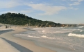 a sandy beach next to a body of water