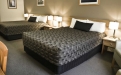 a bedroom with a bed and desk in a hotel room