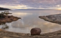 a group of people on a rocky shore next to a body of water