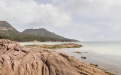 a rocky beach next to a body of water