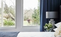 a large white bed sitting next to a window