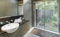 a white sink sitting under a window next to a glass shower door