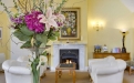 a living room filled with furniture and vase of flowers on a table