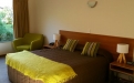 a bedroom with a bed and desk in a hotel room