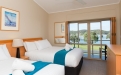 a bedroom with a bed and desk in a hotel room