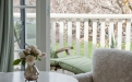 a room filled with furniture and vase of flowers sitting on a bed