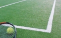 a green ball on a court with a racket