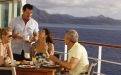 a group of people sitting at a table in front of water