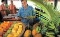 a group of people sitting at a fruit stand