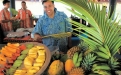 a group of people sitting at a fruit stand