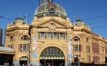 a group of people walking in front of Flinders Street railway station