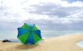 an umbrella sitting on top of a sandy beach