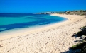 a sandy beach next to a body of water