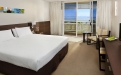 a bedroom with a bed and desk in a hotel room