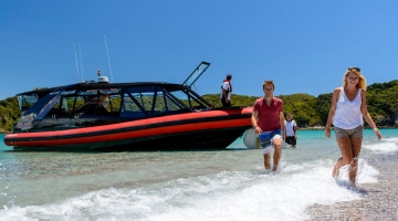 a group of people riding on the back of a boat in the water