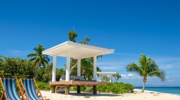 a group of lawn chairs sitting on top of a sandy beach