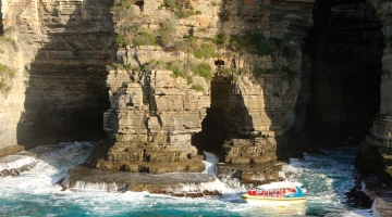 a stone building that has a rocky cliff