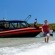 a group of people riding on the back of a boat in the water