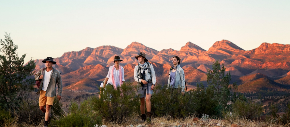 a group of people standing in front of a mountain