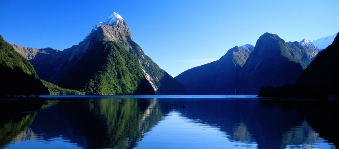 a body of water with Milford Sound in the background