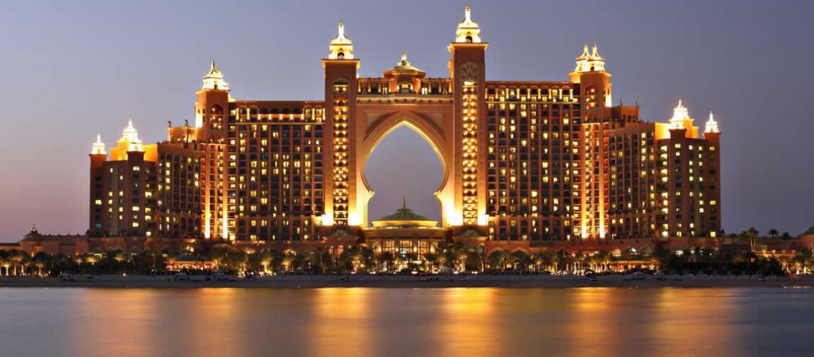 a view of a large bridge lit up at night with Atlantis, The Palm in the background