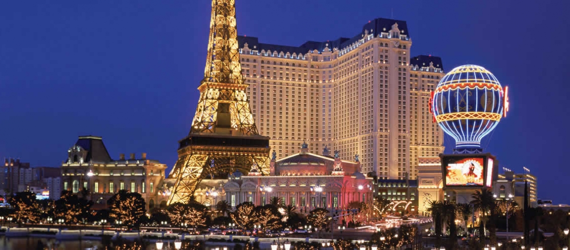 a group of people in front of a tall building with Paris Las Vegas in the background