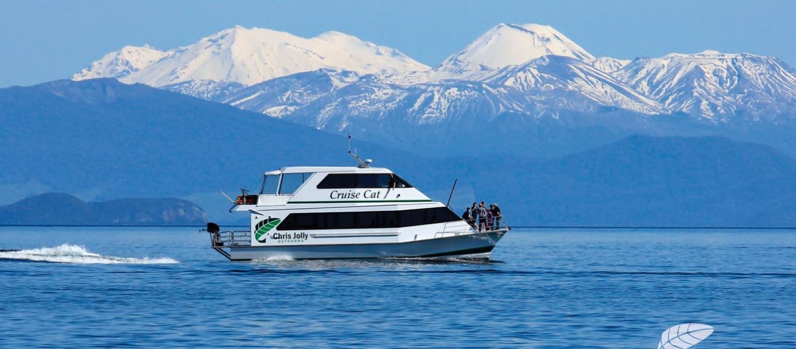 a small boat in a body of water with a mountain in the background