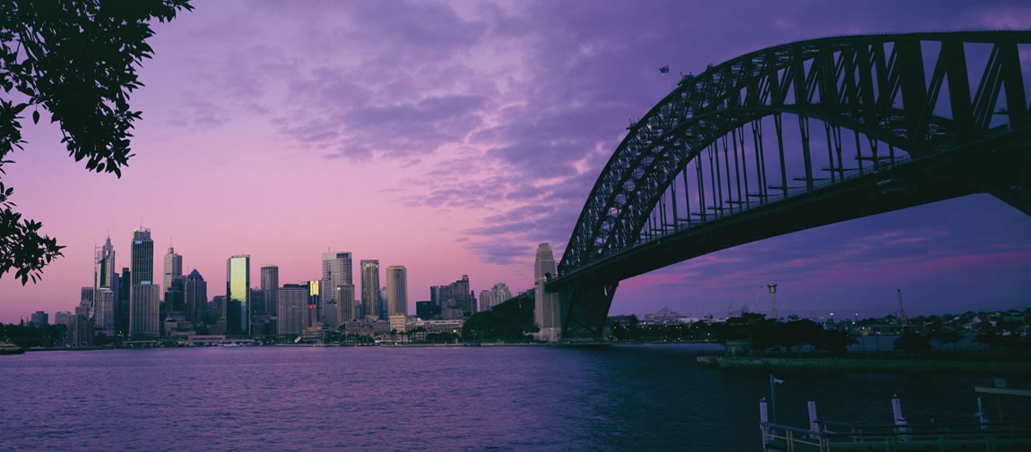 a bridge over a body of water with a city in the background