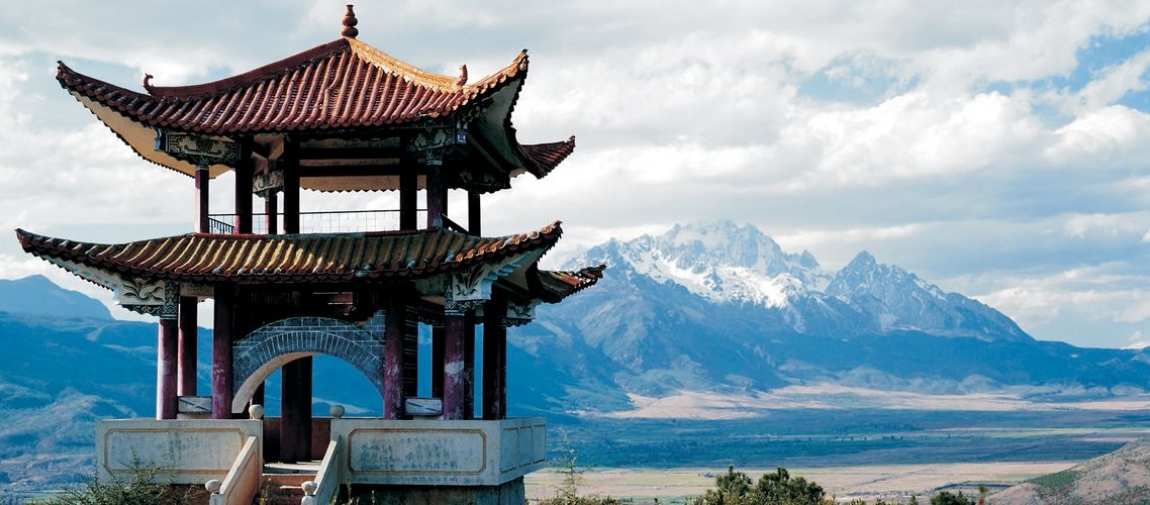 a bridge over a body of water with a mountain in the background