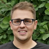 a man wearing glasses and smiling at the camera