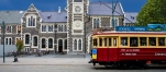 a train driving down the street in front of a building