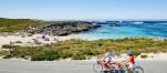 a person riding a bicycle next to a body of water