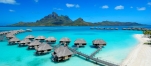 a blue umbrella next to a body of water with Bora Bora in the background