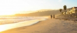 a group of people walking on a beach