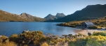 a body of water with Cradle Mountain in the background