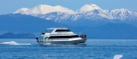 a small boat in a body of water with a mountain in the background