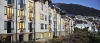 a large white building with a mountain in the background