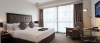 a bedroom with a bed and desk in a hotel room