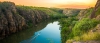 a close up of a hillside next to a body of water