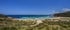 a sandy beach next to a body of water