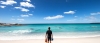 a man standing on a beach near a body of water