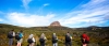 a group of people in a field with a mountain in the background