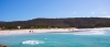 a sandy beach next to a body of water