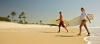 a couple of people that are walking on the beach