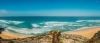 a sandy beach next to the ocean